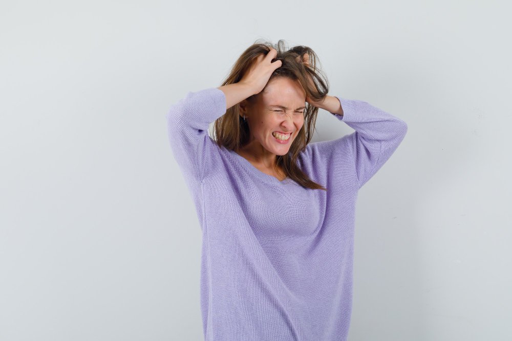 Mujer experimentando un ataque de ansiedad con síntomas físicos visibles.